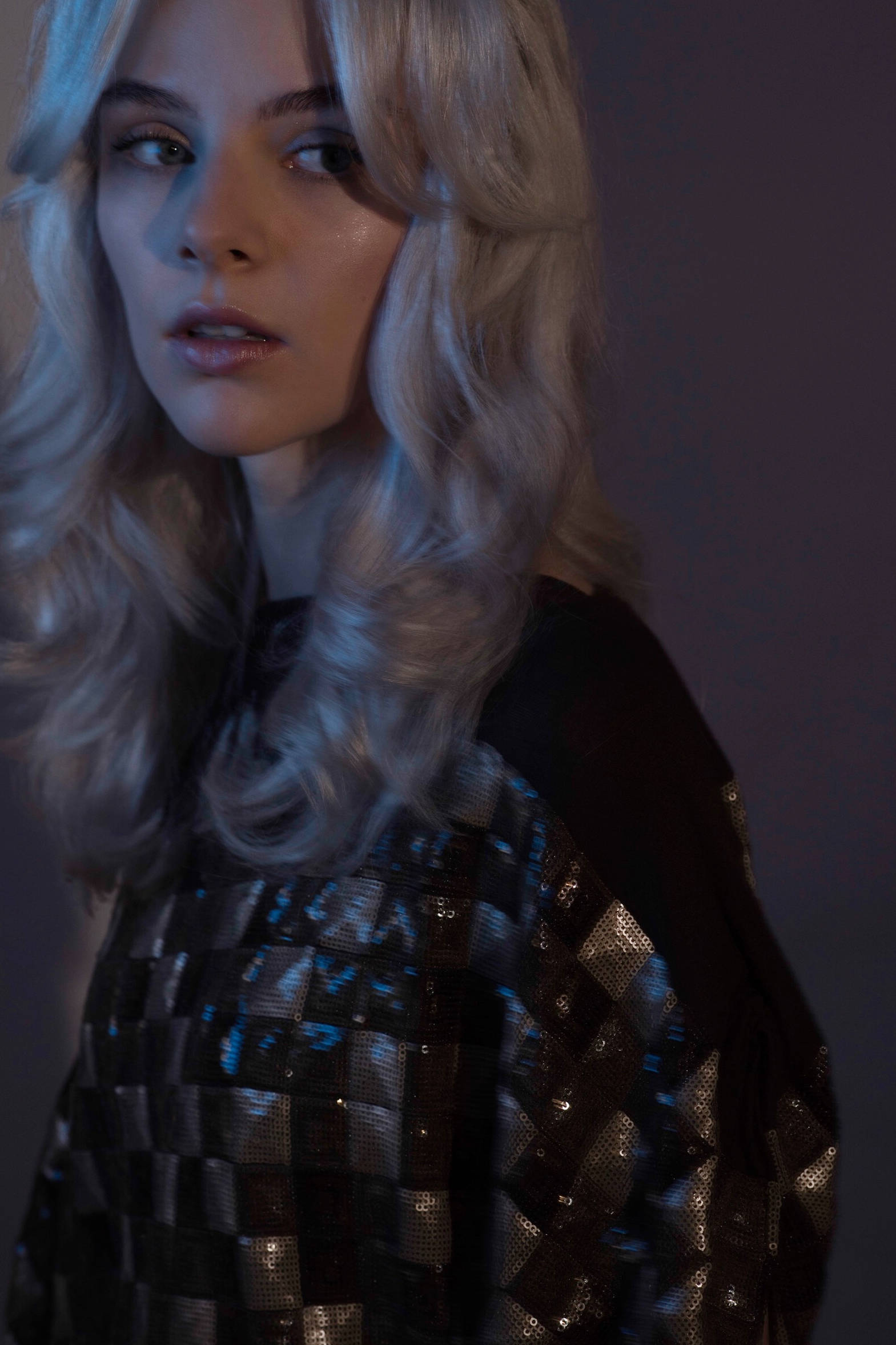 Model mit hellblonden, voluminösen Retro-Locken und Make-up mit silbernem Glitter gestylt von Hair & Make-up Artist Eva Gerholdt